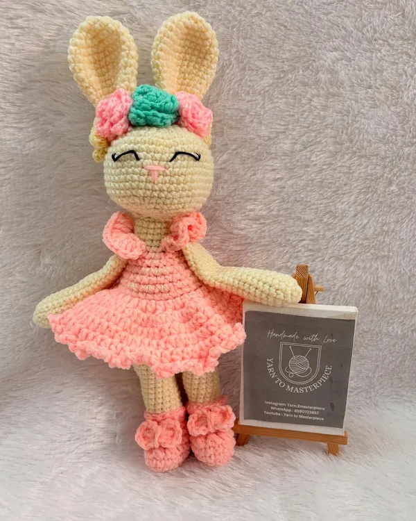 This sweet 10-inch bunny is dressed in a pink ballerina-style dress and has a floral bow. She is made with baby-safe cotton yarn.