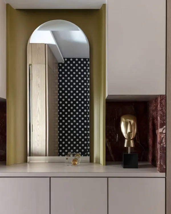 Golden hour, golden accents. This bar unit mixes luxe marble cladding and subtle glam. The cheeky polka dot wallpaper reflected in the mirror is one of those small details that brings joy to a space.