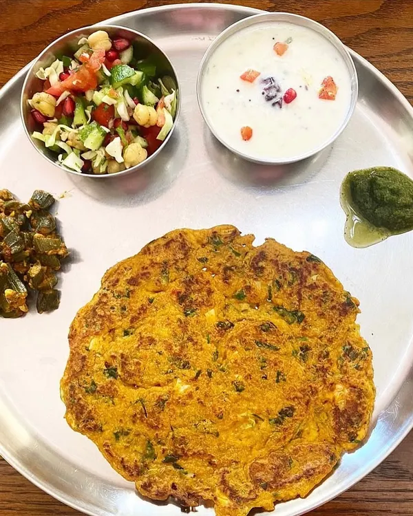 A simple, home-cooked meal is the cornerstone of good health. This plate features a methi paneer roti, okra with peanuts, a chickpea salad, and Greek yogurt. It's a perfect example of a balanced, nutrient-dense meal that I help my clients create.