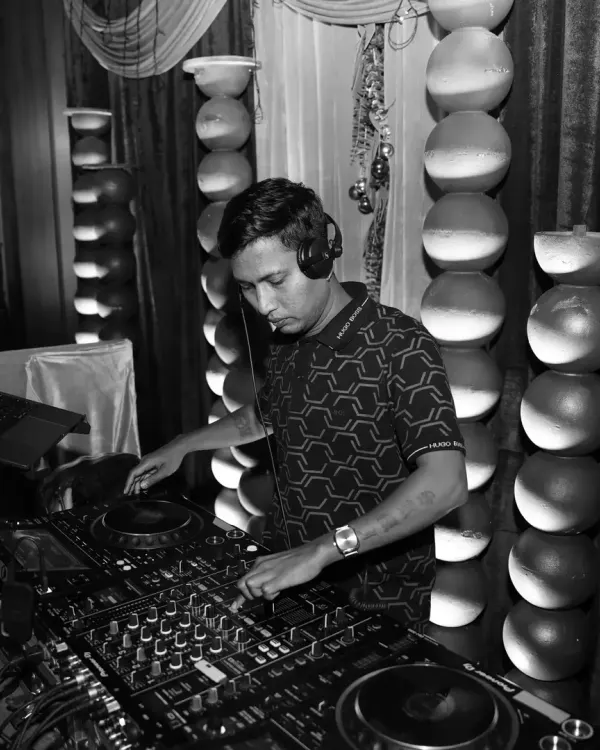 A black and white shot from a pre-wedding Sangeet event. I'm in the zone, focused on crafting the perfect mix for the night.