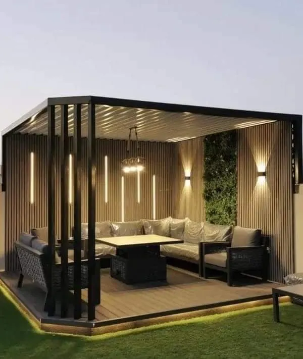 A modern pergola defines this rooftop seating area, featuring integrated vertical lights and a living green wall. This setup is ideal for evening gatherings, providing both style and comfortable seating for guests.