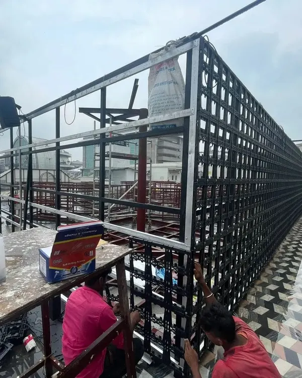 Our team at work on a large-scale rooftop installation. This image shows the metal framework and modular panels being assembled, which form the base of our vertical gardens.