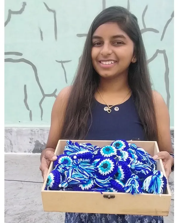 The artist with her proud art. This was my first ever bulk order of 40 evil eye keychains, a huge milestone for my small business that I'll never forget.