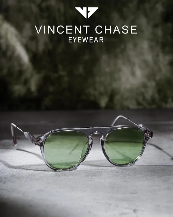 A professional product shot for Vincent Chase eyewear, featuring sunglasses against a textured, atmospheric background. This style elevates the product for a premium brand campaign.