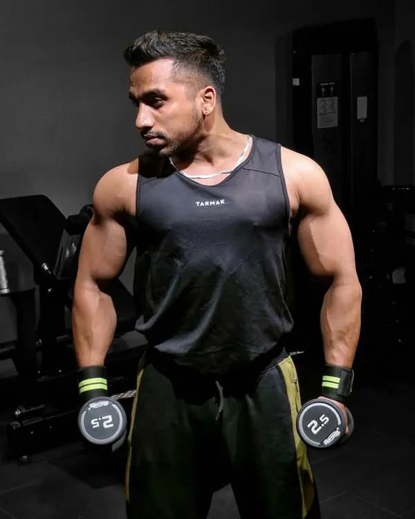 Focused and ready for a dumbbell workout. Maintaining a lean, muscular physique requires year-round dedication, even when not in active contest prep.