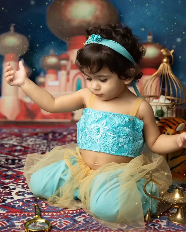 A whole new world. This little princess is dressed as Jasmine, exploring a magical Agrabah-inspired set complete with a magic carpet and lamp.