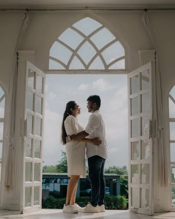 A beautiful silhouette shot of a couple framed by large, white arched doors. This image has a grand and romantic feel, using the architecture to create a stunning composition.