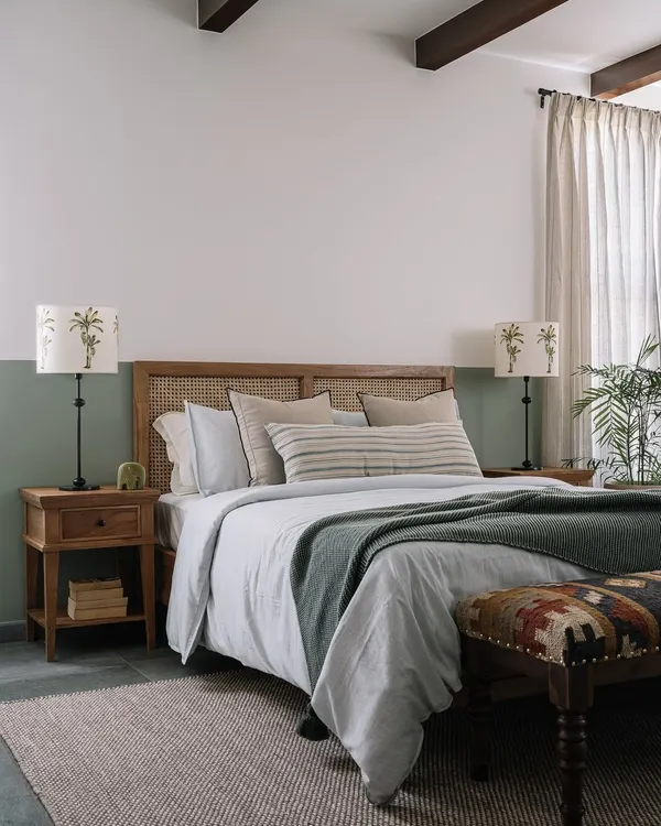 This bedroom has a calm, laid-back vibe with its half-painted sage green wall and cane headboard. We take our bedrooms seriously, and little details like the palm tree lampshades go a long way in making them feel just right.