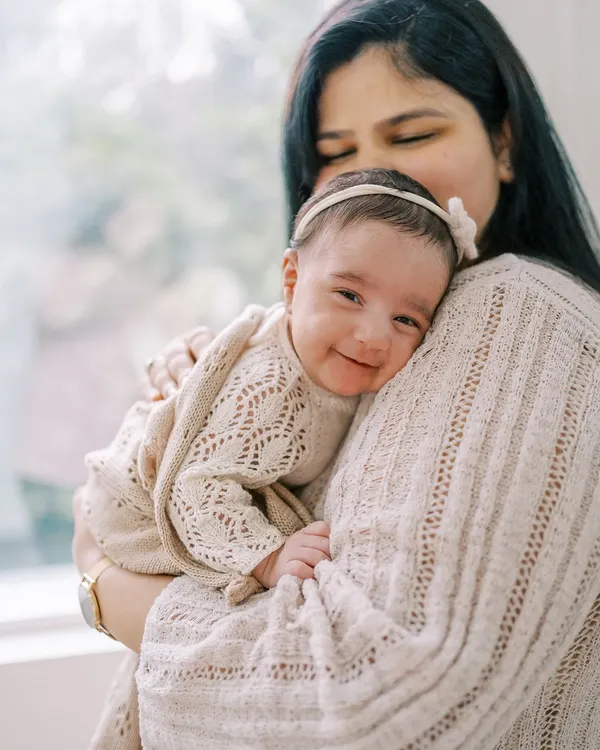 This is the magic I look for. A tiny, perfect smile from a newborn girl, feeling safe and loved in her mother's arms during a gentle, at-home lifestyle session.