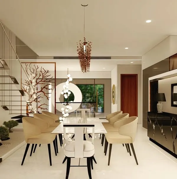 This dining space is set against the backdrop of a modern, floating staircase and an indoor Zen garden. The minimalist white dining table is surrounded by comfortable beige chairs, creating a serene and sophisticated area for meals.