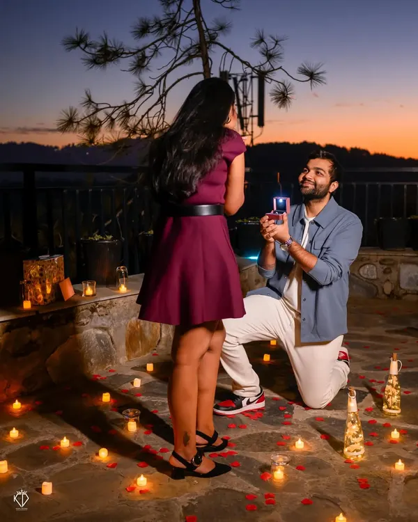 The big moment! A surprise proposal captured at dusk, with the ring box lit up and the background filled with candles and the beautiful twilight sky.