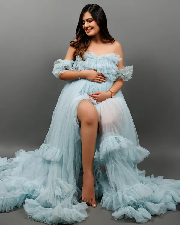 This is the magic I love to create. A serene portrait of a mother-to-be, embracing the quiet strength and beauty of her pregnancy journey. Dressed in a flowing light blue tulle gown against a classic studio backdrop, this image is all about celebrating the incredible transformation of motherhood.