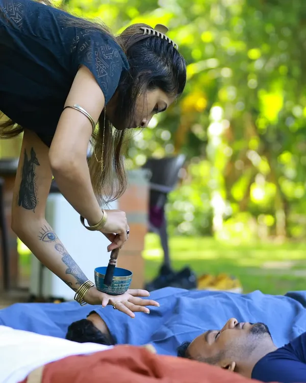 In a quiet moment during an outdoor session, I use a traditional Tibetan singing bowl to create focused vibrations. Placing the bowl near the client's hand allows the healing frequencies to travel directly through the body, promoting deep cellular relaxation and energy alignment.