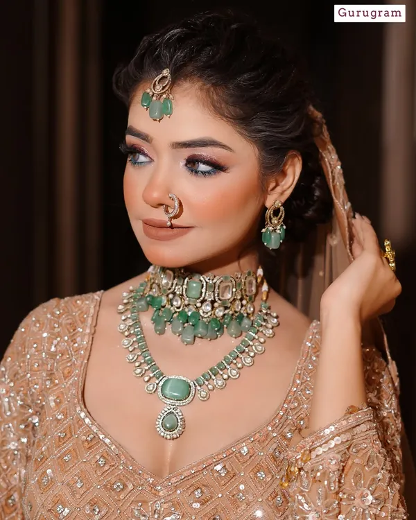 This is a perfect example of the modern bridal aesthetic I teach, featuring soft glam with emerald jewelry. The focus is on creating luminous skin and defined eyes, a look many contemporary brides request.