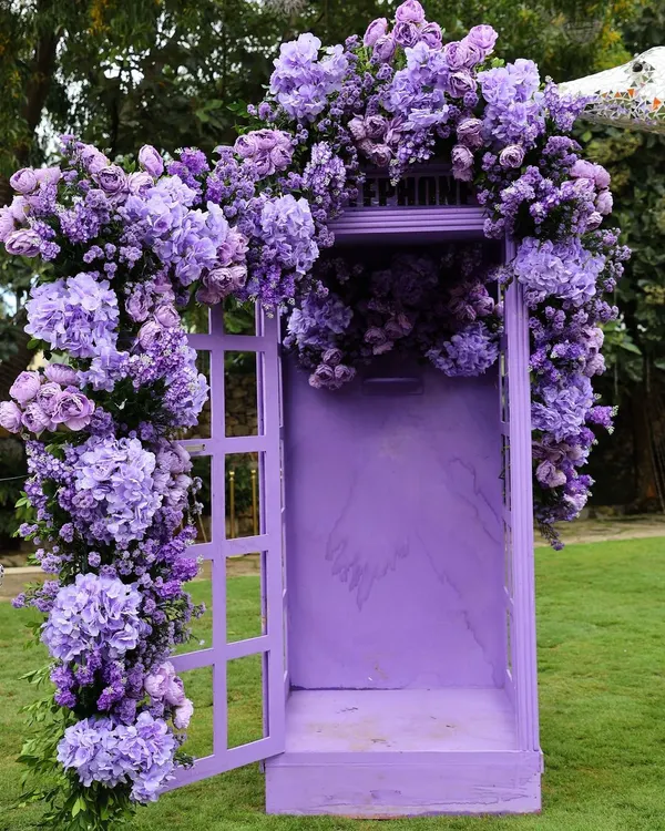 A truly unique photo booth: a vintage-style telephone booth painted purple and overflowing with matching hydrangeas.