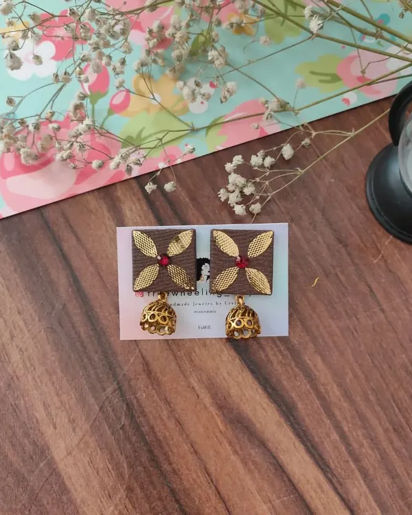 These square fabric earrings feature beautiful gotapatti work and are finished with a classic golden jhumki. This pair is in a lovely brown, perfect for pairing with earthy tones.