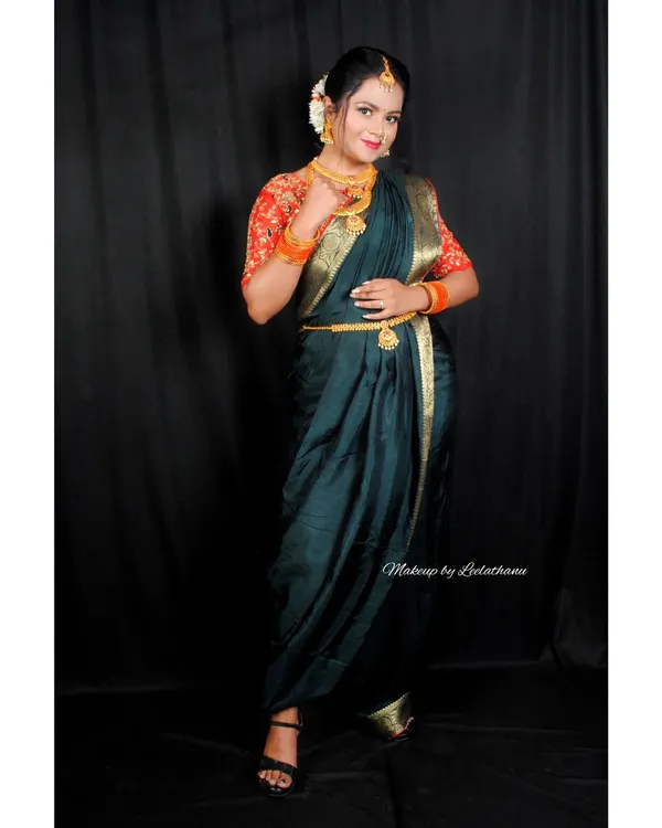 A model showcasing a traditional Marathi look. This features the iconic crescent-shaped bindi and a classic saree drape, paired with festive makeup.