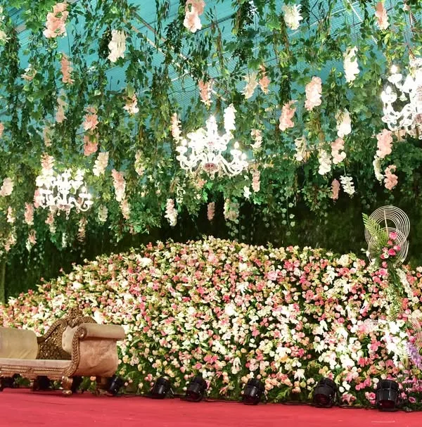This is the kind of grandeur we love to create. For this wedding reception, we designed a massive stage completely covered in thousands of fresh pink and white flowers, with a lush floral ceiling and elegant chandeliers to create a breathtaking, fairytale-like atmosphere.