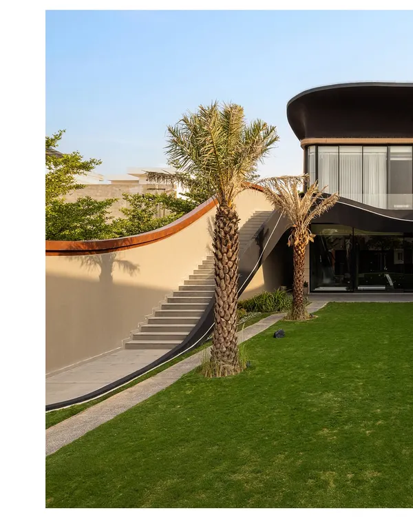 At Residence Ondra in Amritsar, movement is orchestrated for clarity and connection. A sculpted external staircase curves gracefully alongside a textured wall, leading guests directly to an upper-level party lounge while preserving the privacy of the main home.