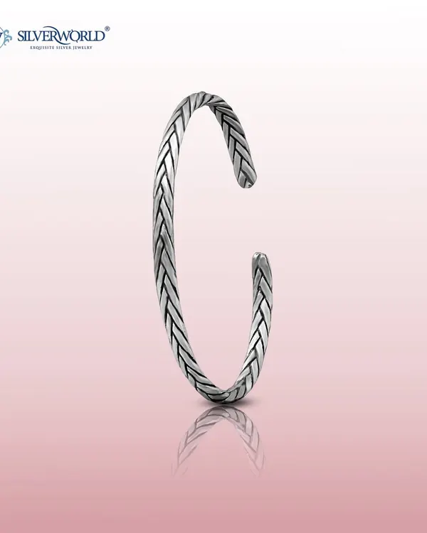 Our braided silver open-cuff bangle, or kada. The oxidized finish gives it a vintage feel, and the open design allows for slight adjustability for a comfortable fit.