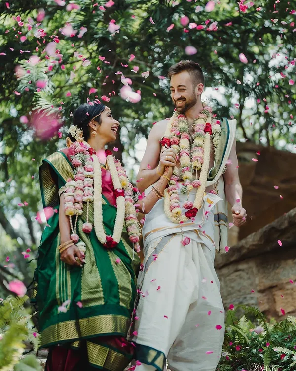 An Indian bride and her groom from New Zealand share a joyous moment, celebrating their union with a mix of South Indian and Māori traditions.
