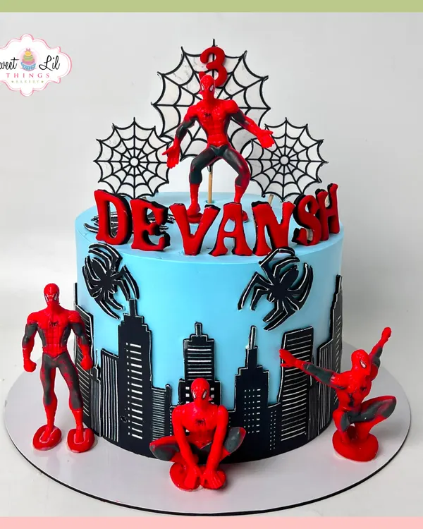 This Spider-Man cake is an action-packed scene, featuring a city skyline wrapping around the base and multiple Spidey figures in dynamic poses. The bold red and blue colors make it a visually striking centerpiece for a young superhero fan's birthday.