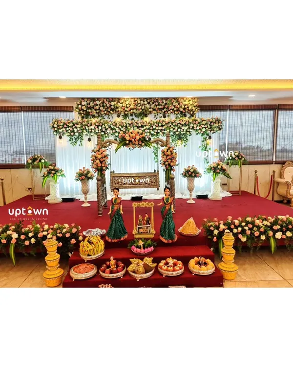 An elegant naming ceremony stage with a floral-decorated cradle and traditional offerings.