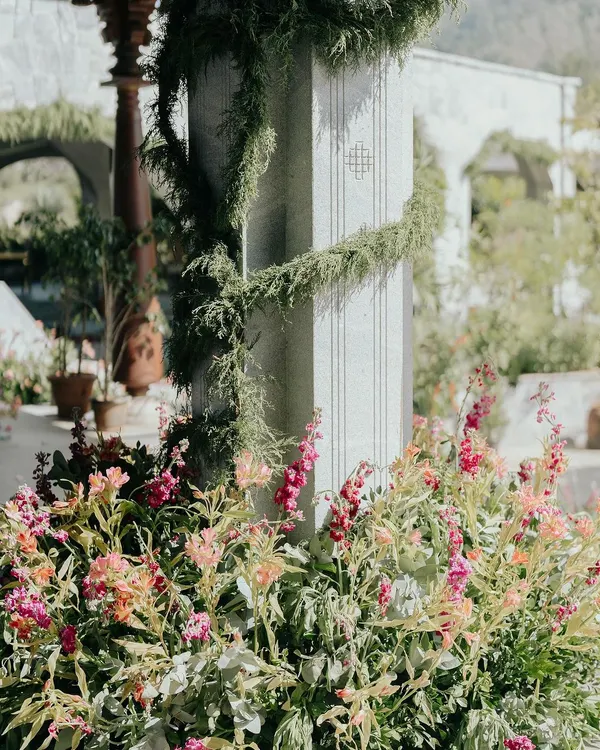A close-up of the floral and greenery details from Nithya and Payton's wedding. We love layering different textures and colors, like these soft pink snapdragons against the cool stone pillar wrapped in delicate vines.