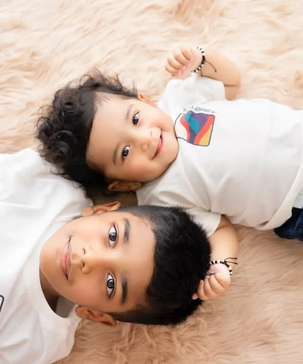 An overhead shot of two brothers lying down, sharing a moment of connection. This perspective offers a unique and intimate view of their bond.