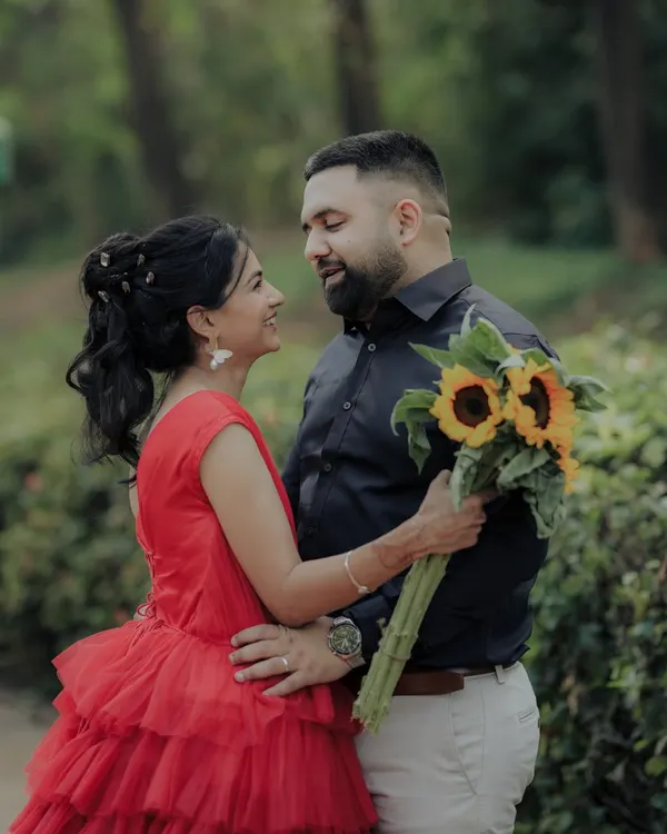 A romantic gaze shared between the couple in a serene garden setting. The sunflowers add a pop of cheerful color, symbolizing adoration and loyalty in this beautiful pre-wedding photograph.