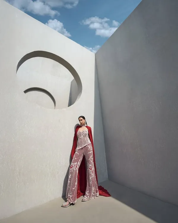 A fully pearl-embellished corset paired with tailored pants and a floor-sweeping crushed cape. This is power dressing, redefined with elegance and edge.