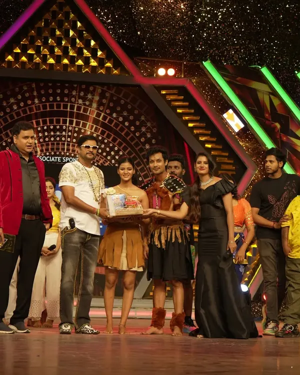 On stage during the 'Jodi No. 1' semi-finals, presenting an award to the contestants. My role as a judge involves providing constructive feedback and evaluating performances based on technique and creativity.