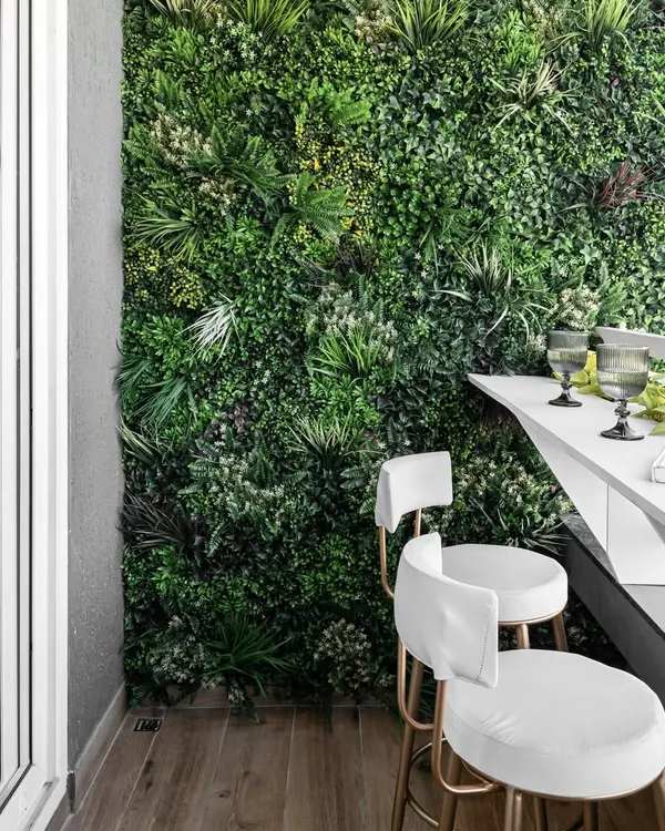 We turned this balcony into a biophilic-themed retreat with a lush vertical garden wall. The sleek white bar counter and matching stools create a perfect spot for morning coffee or evening drinks.