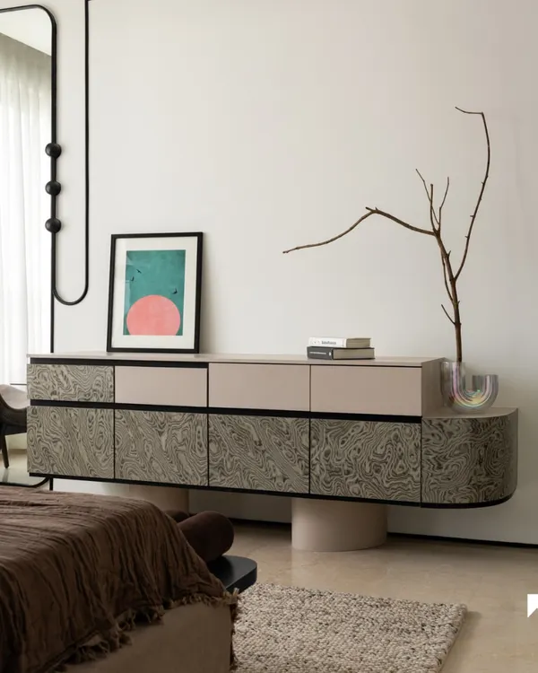 A custom-designed console with a unique swirling veneer finish stands as a functional art piece in the bedroom. Paired with a bespoke full-length mirror, it creates a cohesive and elegant corner that balances form and storage.