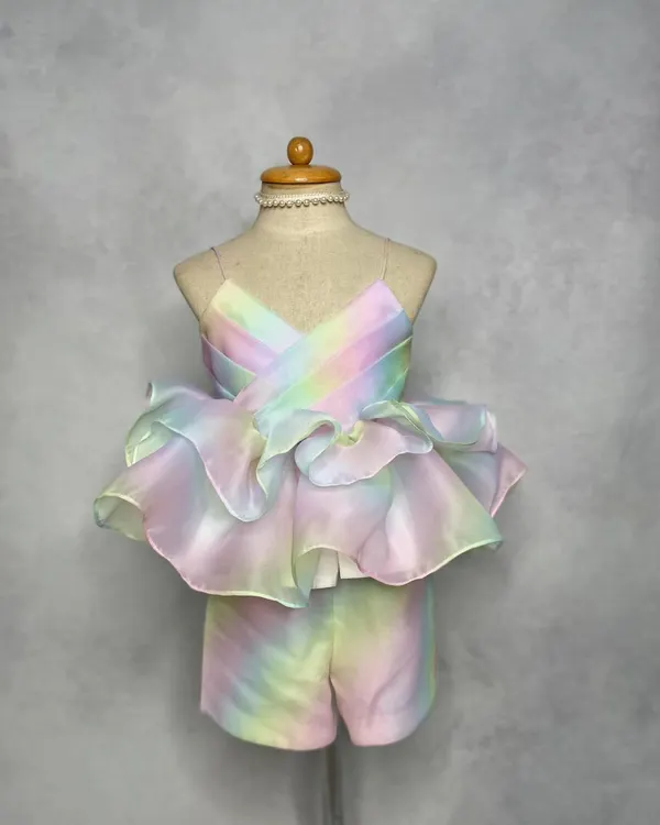 Our most-loved Rainbow Co-ord set. This dreamy pastel outfit features a strappy top with dramatic organza ruffles and matching shorts, perfect for a stylish birthday or vacation look.
