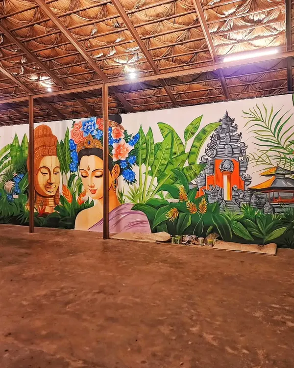 A wide view of the expansive Bali-themed mural we painted for Vanya Bangalore. The artwork wraps around the space, creating an immersive tropical escape with its depiction of Balinese temples, lush foliage, and serene figures.