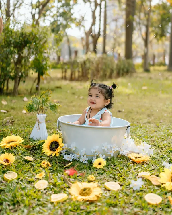 Splish, splash in the sunshine! This outdoor tub session, surrounded by grass and sunflowers, is a perfect example of a fun and unique outdoor shoot.