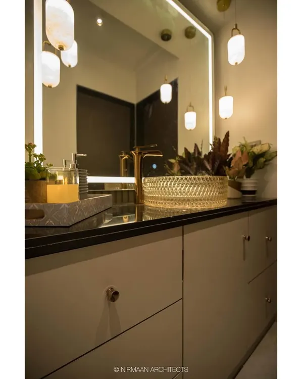 This elegant wash area in our Duplex Project features a stunning crystal-cut glass basin and gold-finished tap. The pendant lights and backlit mirror add layers of warm, ambient lighting.