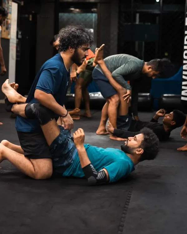 Students practice passing the guard during a Jiu-Jitsu class. This is a fundamental skill for advancing to a more dominant position.