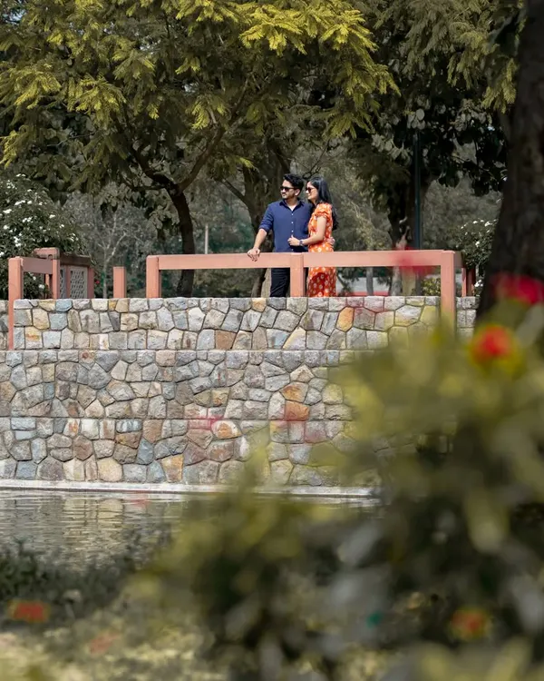 This is a classic outdoor pre-wedding portrait taken at a park in Delhi. I use natural light and scenic elements like this stone bridge to create beautiful, relaxed images for couples.