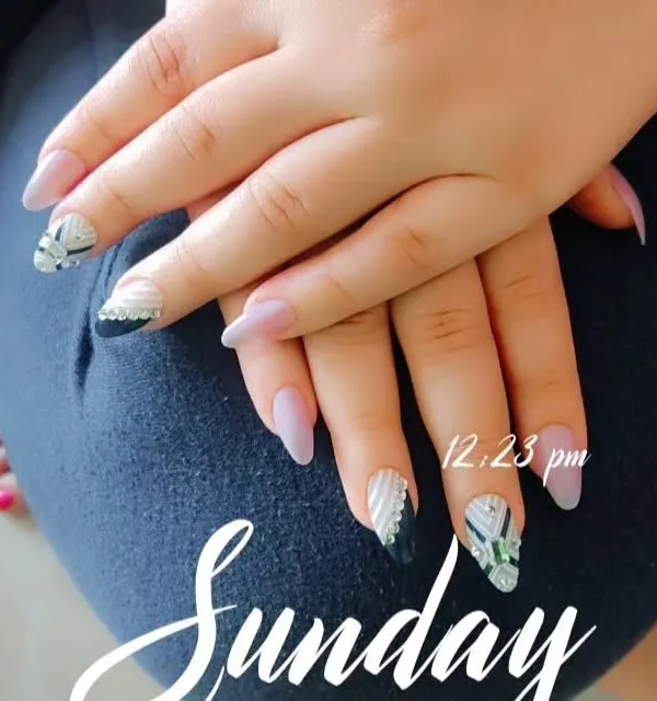A modern nail art set featuring a mix of matte nude, black, and textured silver geometric designs on long, almond-shaped extensions.