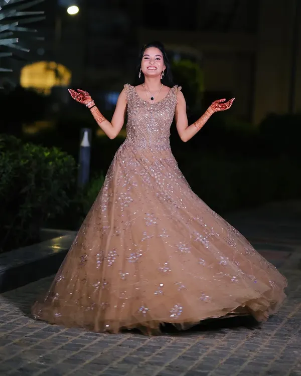 A happy and twirling engagement bride in a stunning beige gown. The makeup is kept soft and glowing to let her natural joy shine through.