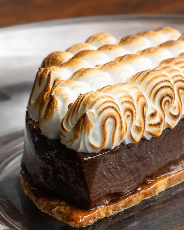 First bites, shy smiles, and spoons meeting over my Hazelnut Chocolate dessert. A crisp praline base, dark chocolate mousse, and soft torched meringue make for a perfect ending.