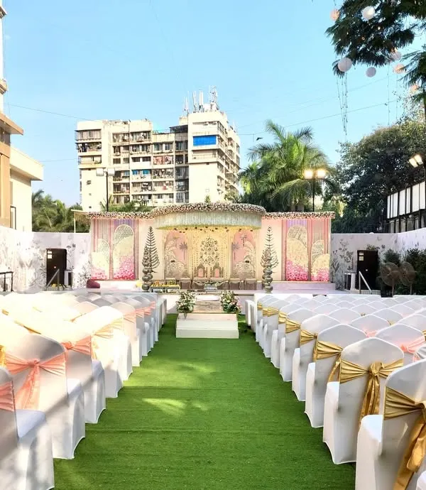 This image shows how I can transform an outdoor space at Siddharth Banquets for a beautiful daytime wedding. The open-air setting allows for a grand mandap setup with clear views, and the guest seating is arranged along a green turf aisle for a garden ceremony feel.
