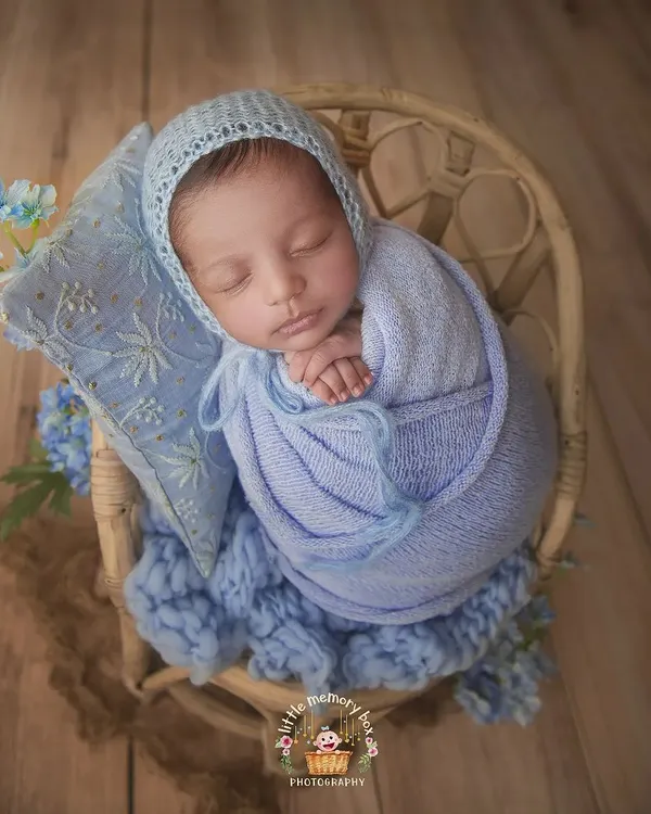 A perfect little bundle in blue. I use soft, textured wraps and a matching bonnet to create a cozy and coordinated look, highlighting the peaceful sleep of a newborn.