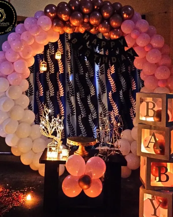 This is one of our popular romantic home birthday setups. It features a circular balloon arch, a "BABY" block display, and soft candlelight to create a cozy and intimate atmosphere perfect for a surprise celebration.