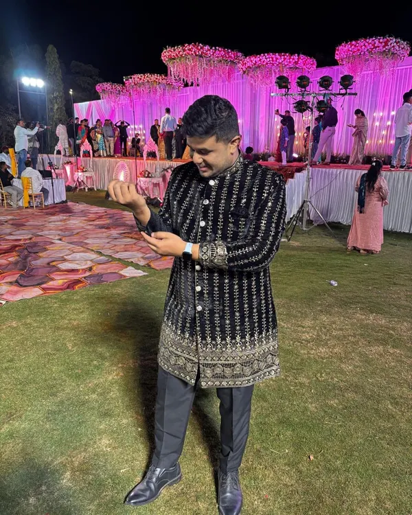 A client looking absolutely ready for a wedding night in our black velvet Jodhpuri. The detailed embroidery shines under the lights, making it a perfect rental for a sangeet or reception.