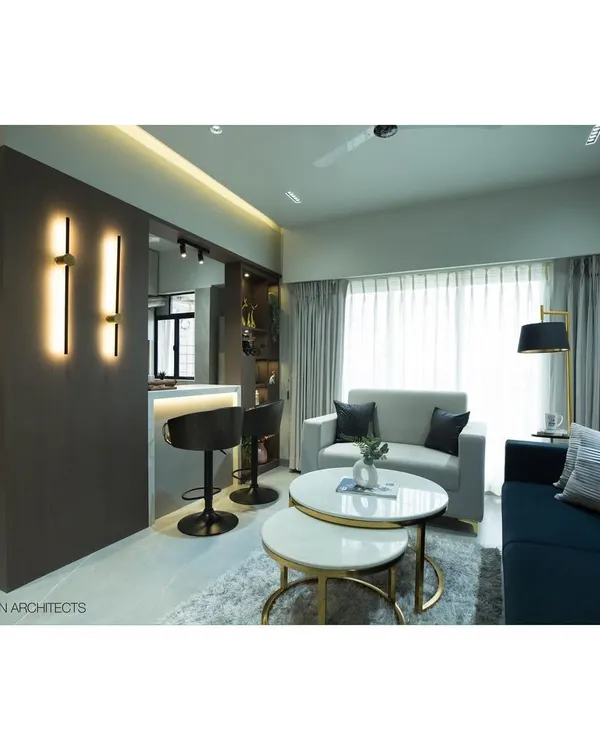 A wide view of the transformed Tulsi Heights living room, showing the open layout with the breakfast bar, modern furniture, and layered lighting that creates a warm, inviting ambiance.