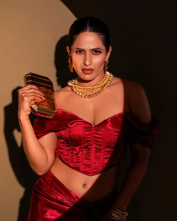 This shot is all about glamour and confidence. I used dramatic spotlighting to create a high-contrast look that emphasizes the rich red of the outfit and the bold gold jewelry.
