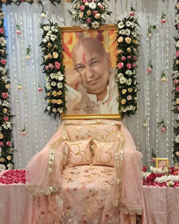 This is a complete altar setup for a Guru Ji satsang. I used columns of white and pink flowers to frame the space, with a sheer curtain backdrop and a decorated throne featuring custom 'Om' pillows. The focus is on creating a serene and devotional atmosphere.